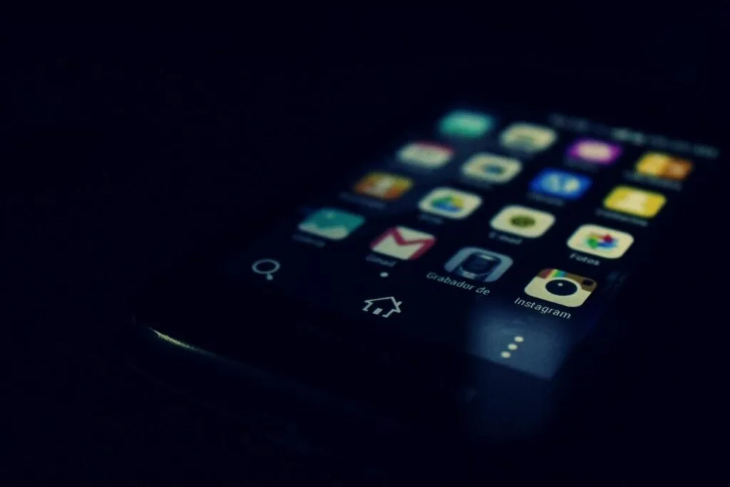 Dark-Themed Close-Up Of A Smartphone Screen Highlighting Various Apps And Touchscreen Technology.