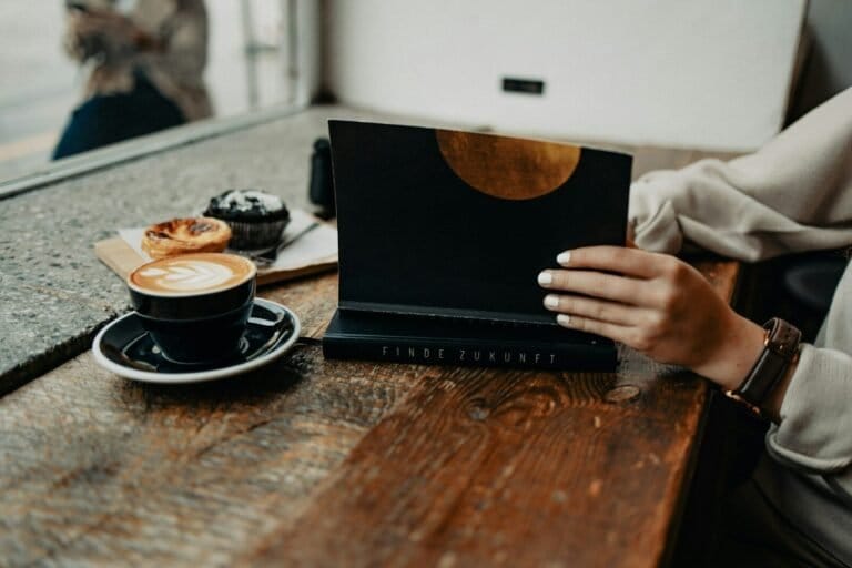 A Woman Sitting At A Table Using A Laptop Computer