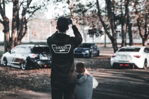 A man standing next to another man in a parking lot