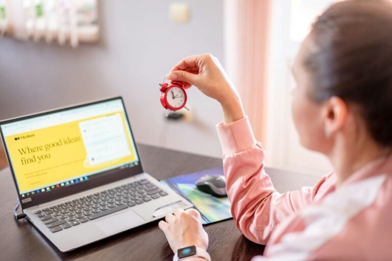 A Woman Sitting At A Desk With A Laptop Computer