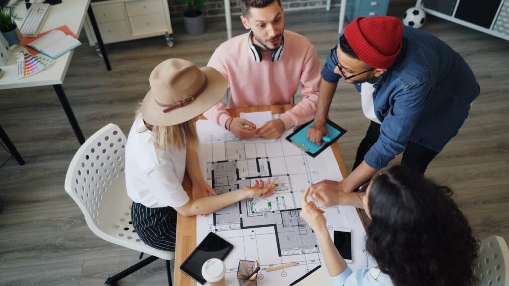 A Group Of People Sitting Around A Table Playing A Board Game