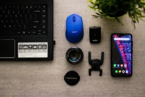 laptop, blue computer mouse, smartphone, and camera lens