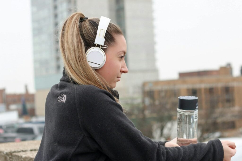 Woman Wearing Black The North Face Jacket And White Headphones