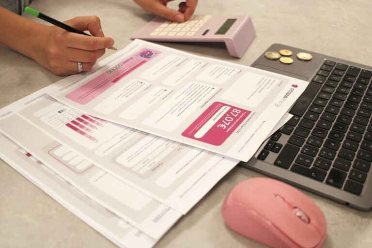 Someone Is Doing Taxes With A Calculator And Laptop.