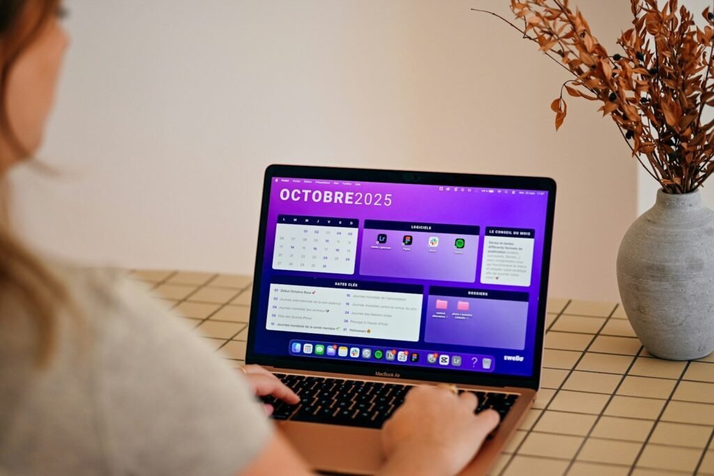Woman Using Laptop With October 2025 Calendar Displayed.