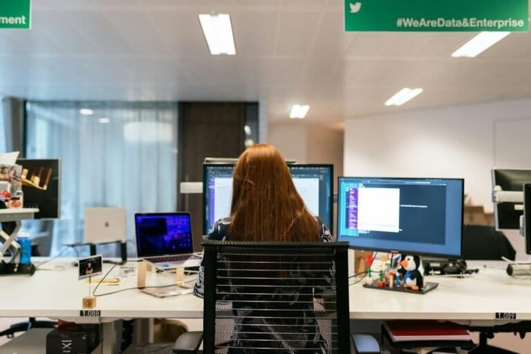 Woman In Black Shirt Sitting On Chair In Front Of Computer