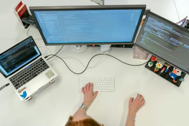 Person Using Macbook Pro On White Table