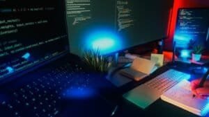 Computer screens displaying code with neon lighting.